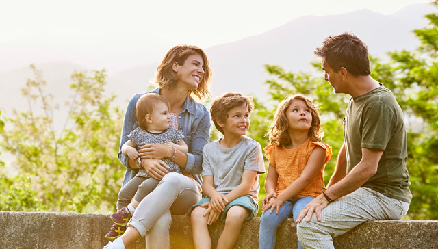 Strona ubezpieczenia na życie i zdrowie Twoje Życie Allianz - rodzice z trójką dzieci siedzący na ławce w parku